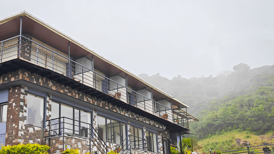 A side angle shot of the facade of the villa with mountains in the background 