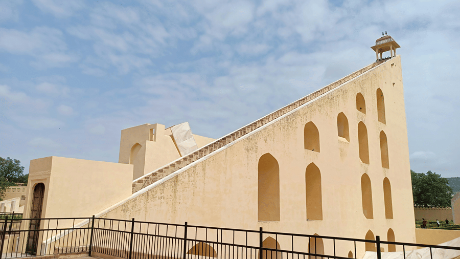 A large cream-coloured stone sundial with a ramp and arched openings at Jantar Mantar, Jaipur
