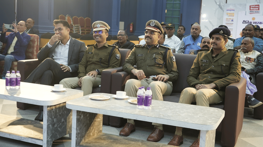 Dignitaries and police officers seated on a sofa during an event at the Ram Bhawan Ram Yamuna Prasad Hotel and Resort.