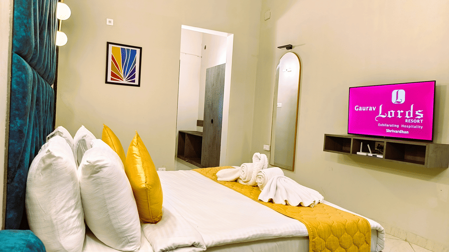 A brightly lit double bed room with AC, decor frame, mirror and hallway