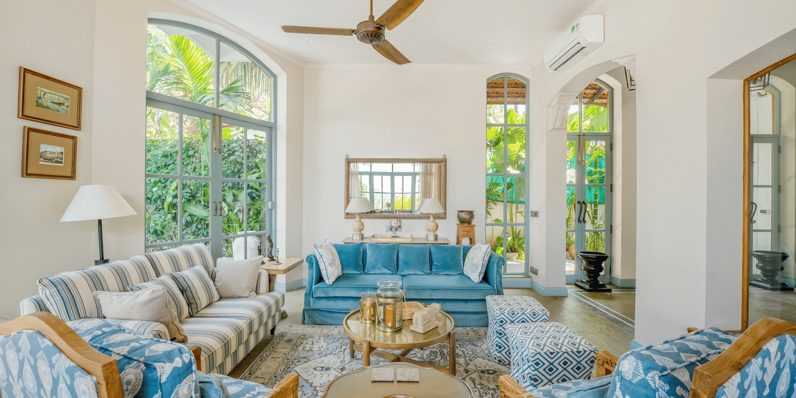 Living room with blue and white furniture, coffee table, and multiple windows at Linday Manor.