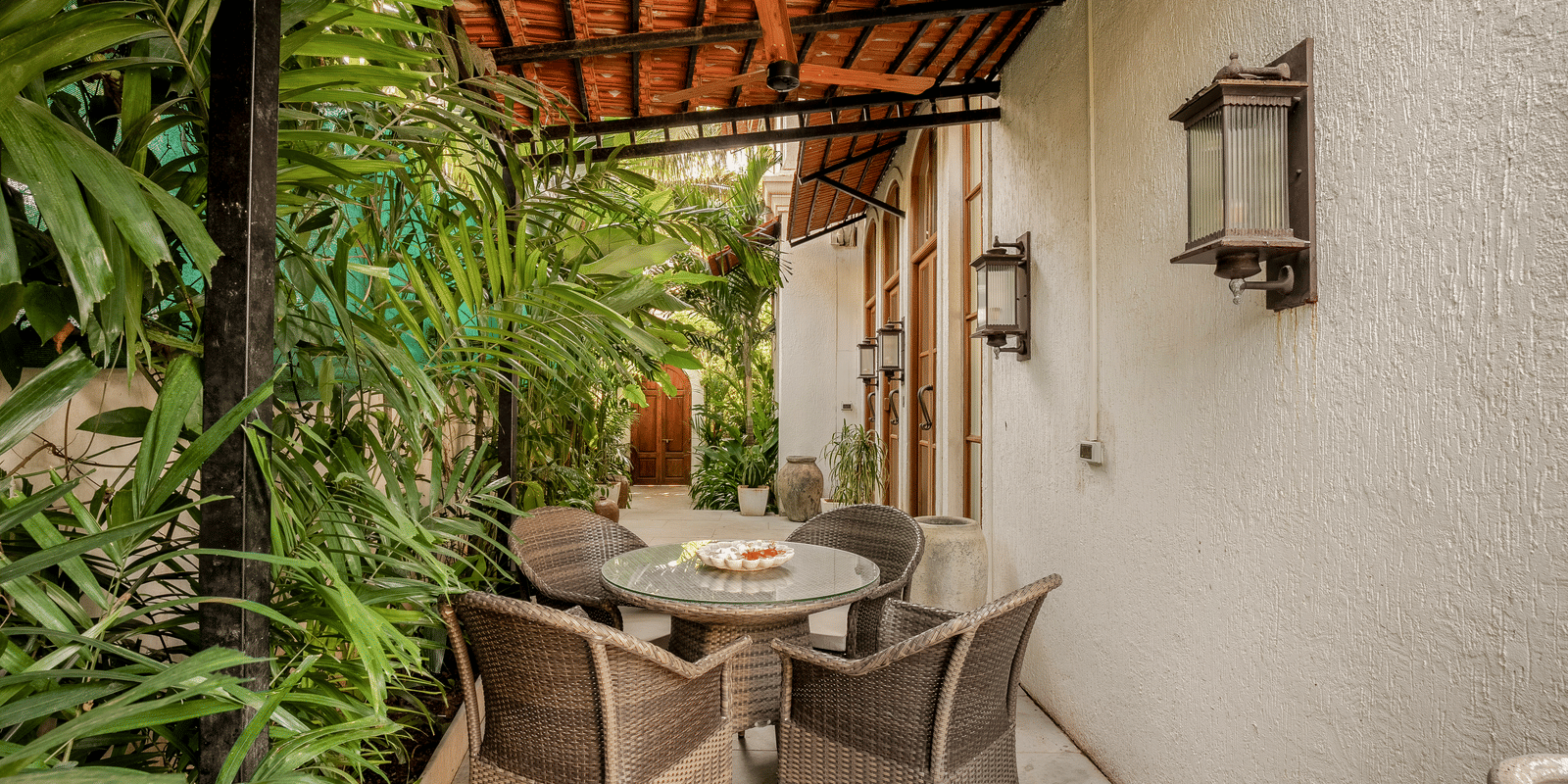 Outdoor dining area with table and chairs surrounded by lush greenery at Linday Manor