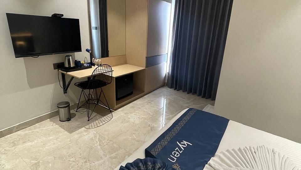 Suite with stylish furniture, including a sofa and writing desk at Hotel Kyzen HiTech City – Your Zenly Stay