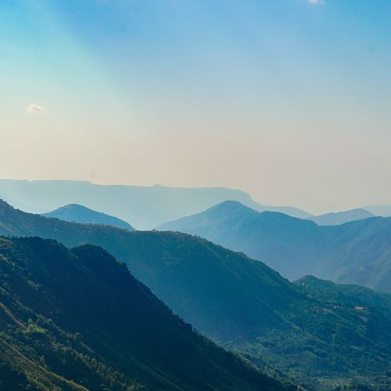 an overview of the mountains in Shillong with blue sky in the background