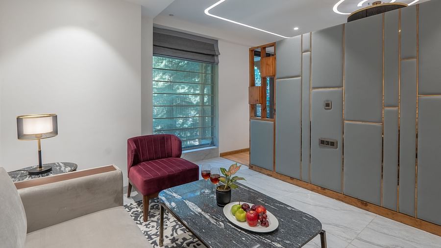 an image of a living area of a suite with a chair and a table at Mastiff Select Mandavya Dharamkot, McLeodganj