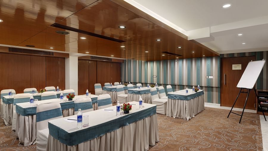 A conference room with tables and chaird and a whiteboad in the corner at The Park Elanza.