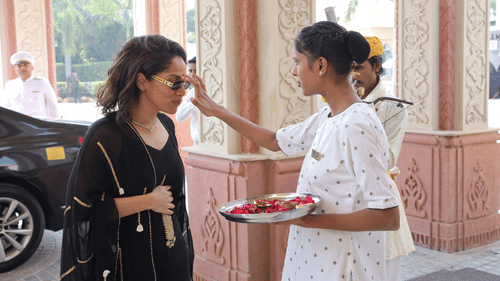 Traditional Indian welcome ceremony with a staff member applying a tilak for arriving guests.