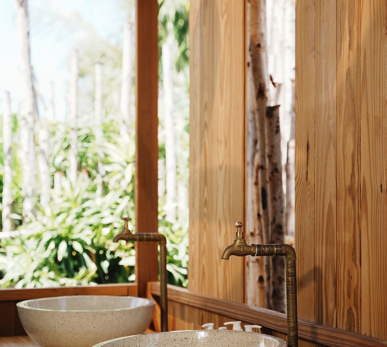 The dual-sink vanity setup in the Peaceful Tent at WoCAL Retreat Ke Ga, with elegant basins placed on a wooden counter in a semi-open space overlooking the lush outdoors.