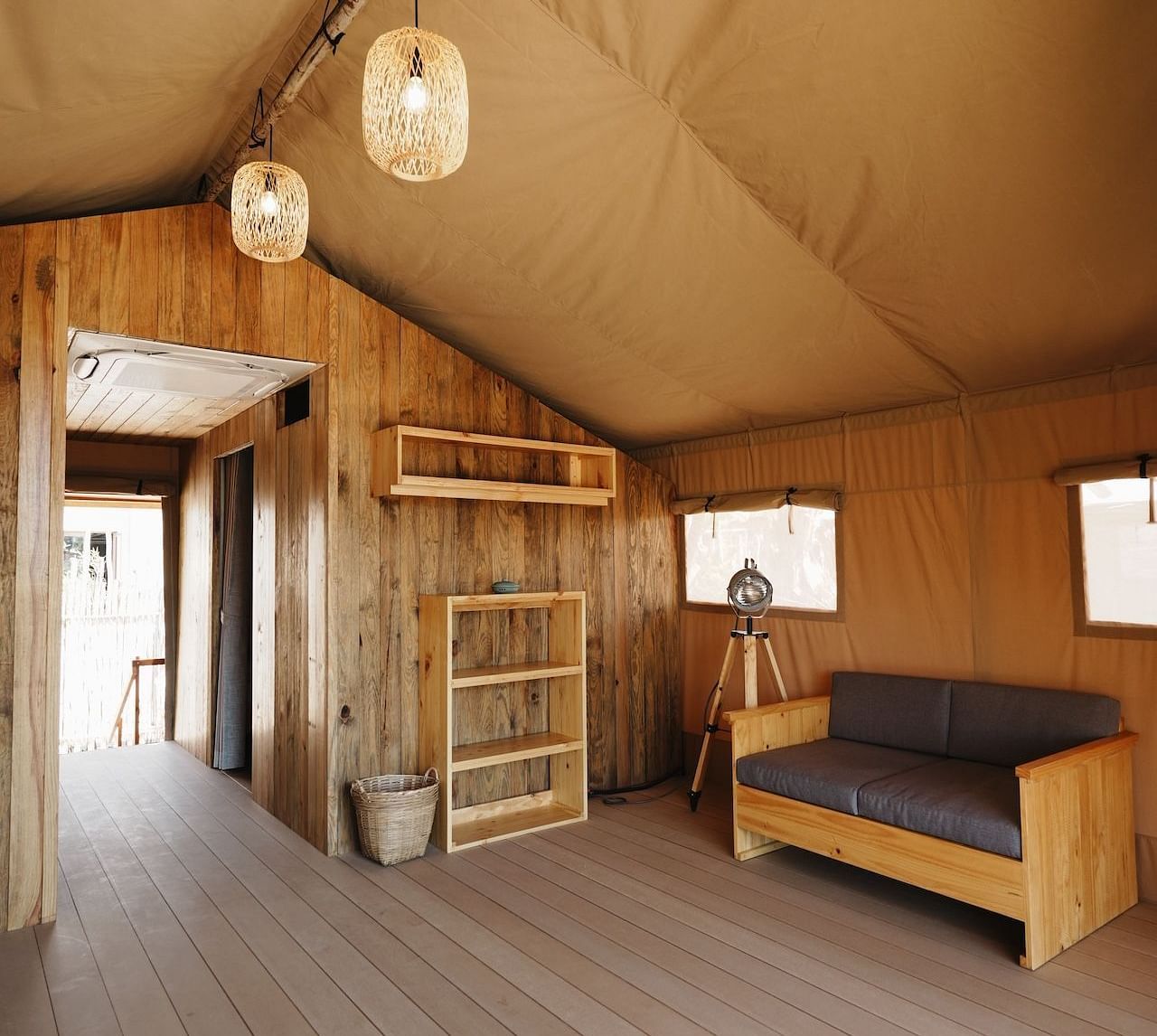 A wide view of the living space inside the Peaceful Tent at WoCAL Retreat Ke Ga, combining functional design with organic textures, and seamlessly opening to views of nature.