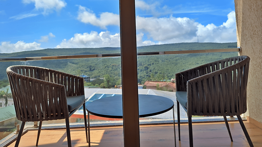 Balcony with outdoor seating overlooking green hills and surrounding scenery