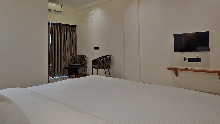 Bedroom with a double bed, television, wooden furnishings, and ceiling lighting.