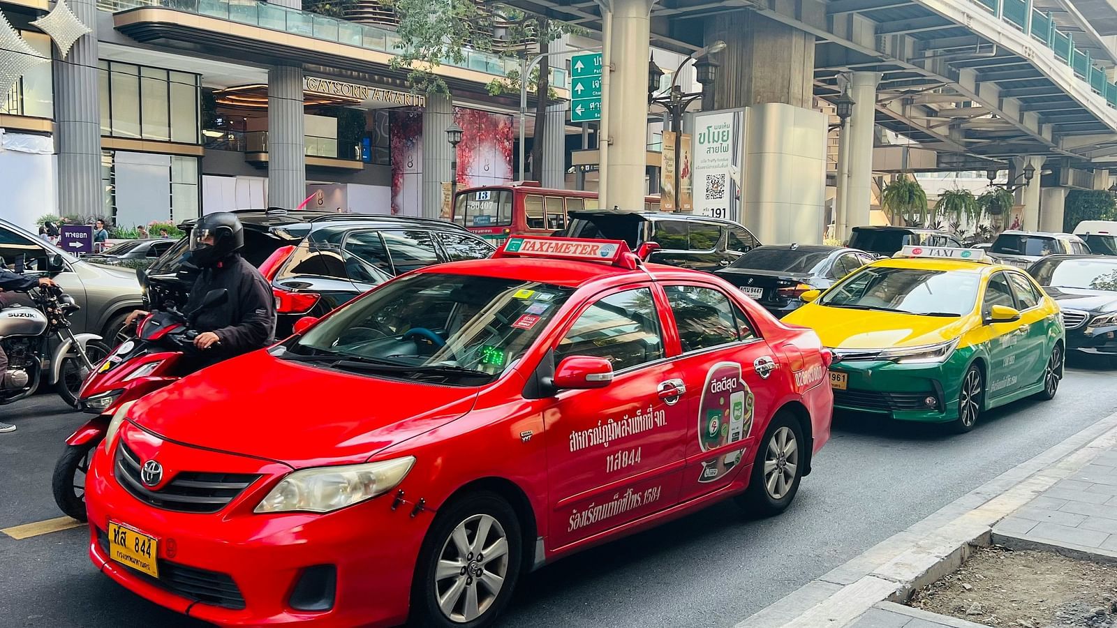 An overview of a road with two taxis parked on the road next to other vehicles.