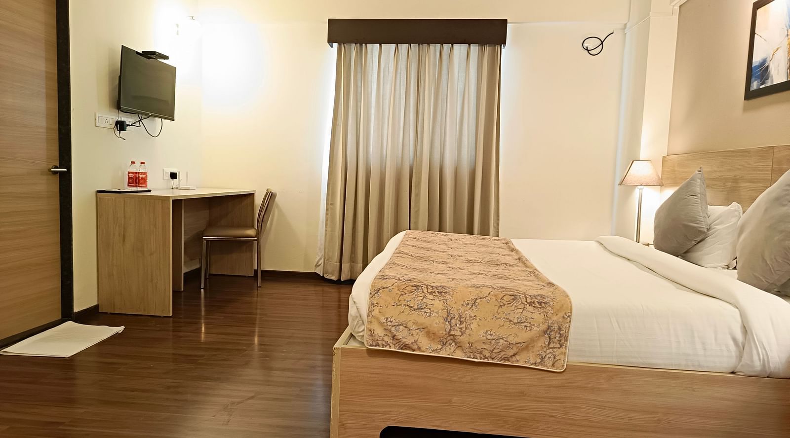 Study table and a TV mounted on the wall above it inside premium studio at Starlit Suites, Shirdi