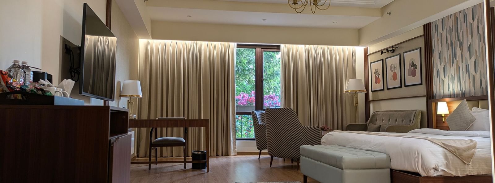 The Premium Room at M2 Square by Monday Premium featuring a double bed with the curtains slightly opened showcasing the lush green views from the huge windows.