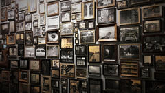 A wall covered with numerous framed photographs and artworks arranged in a collage-like display.