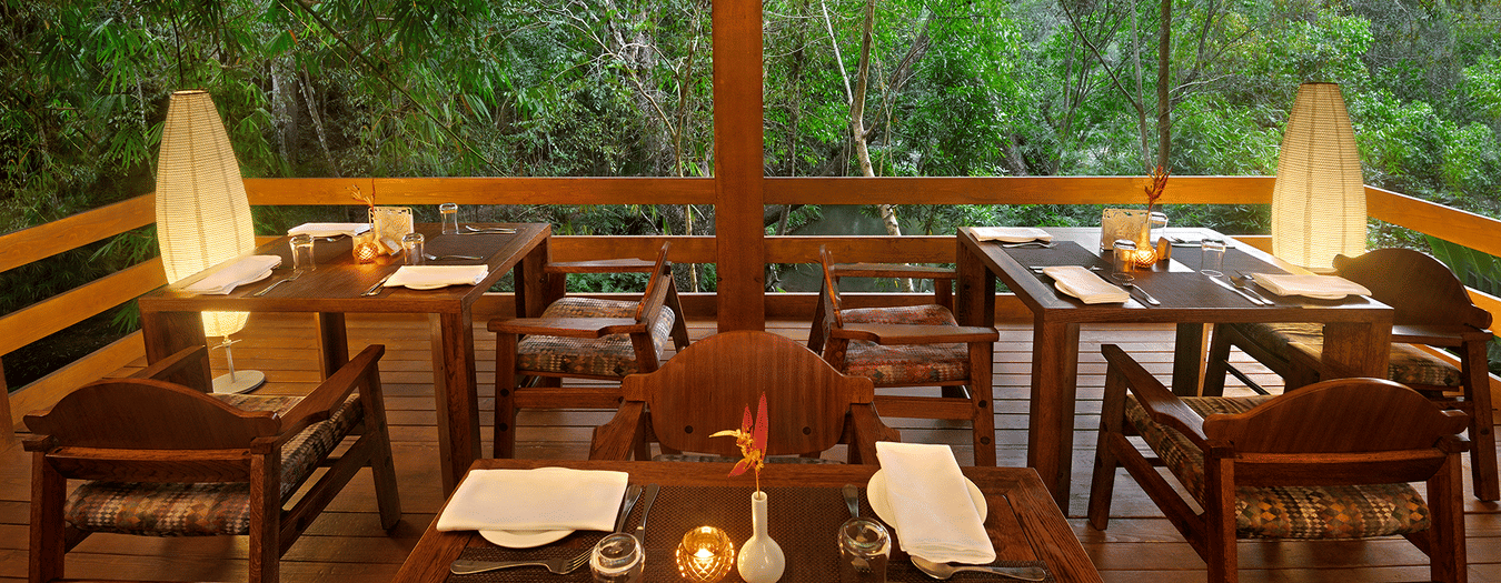 Dining table set inside a room with forest view-Amanvana Spa Resort, Coorg - Luxury Resort