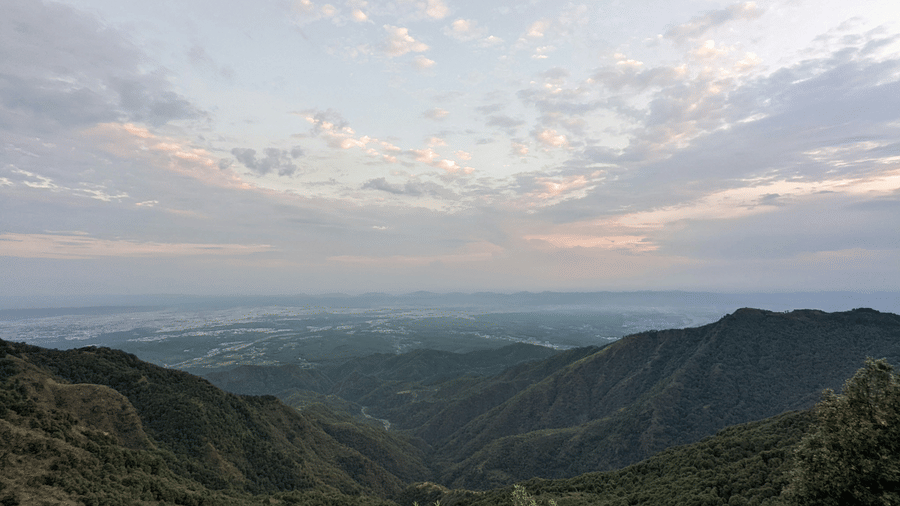 A landscape featuring mountains and valleys under a vibrant morning sky