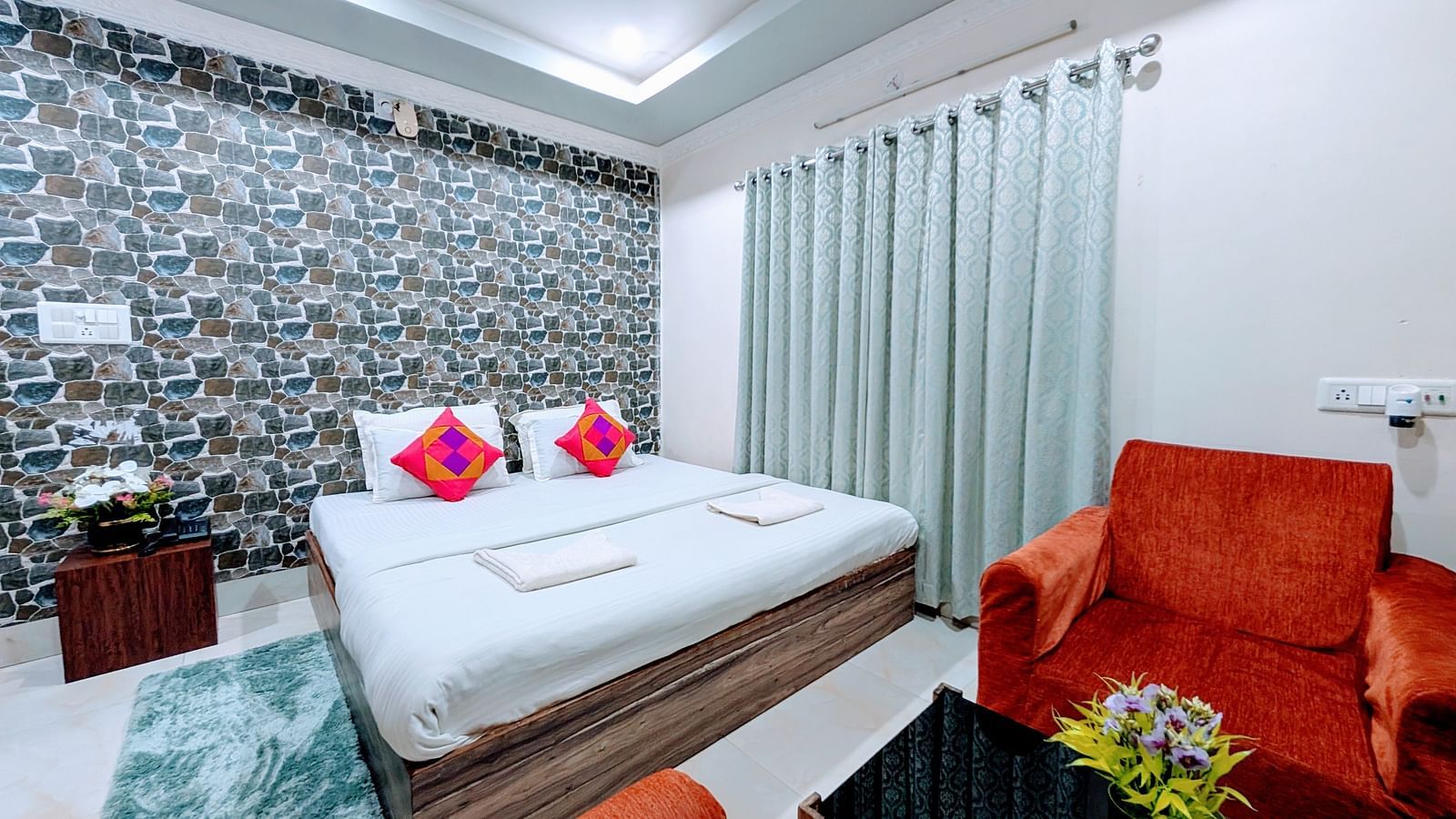 image of the standard room at dip holidays featuring a double bed and orange coloured cushioned couch