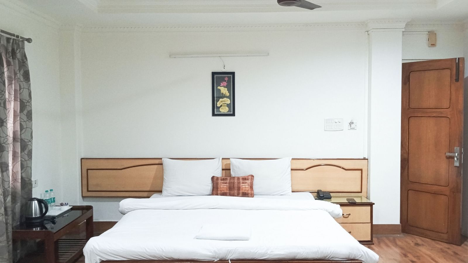 Deluxe Triple Room A.C. at Ecotel Vinayak, Siliguri with twin beds, bright lighting, wooden floor, and classic décor.  