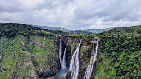 Multiple streams of Seven Sisters Waterfall plunging into a deep gorge surrounded by dense forests in Meghalaya.