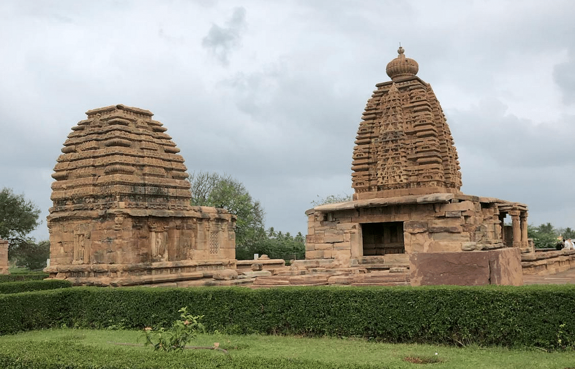 Two rock monuments flanked by neatly cut green shrubs shaped into rectangular form