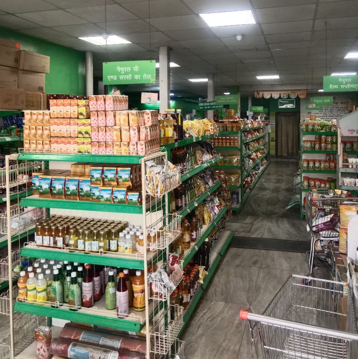 An aisle in a well-lit Patanjali Megastore with shelves stocked with various packaged food products.
