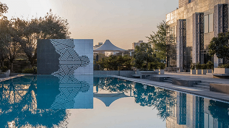 Swimming pool with surrounding buildings and trees at Karma Chalets.