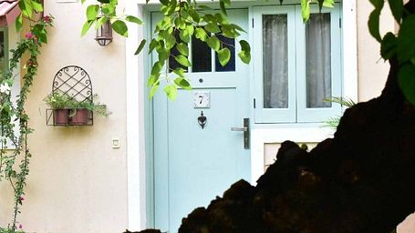 View of a light blue door and vine-covered entrance of a cottage at Karma Chalets.