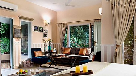 Interior of a guest room with a double bed, sofa, and window view at Karma Chalets.