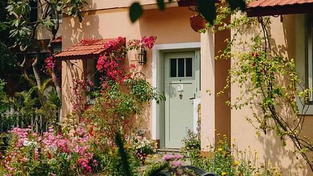 Exterior view of a villa-style building surrounded by plants and flowers at Karma Chalets.