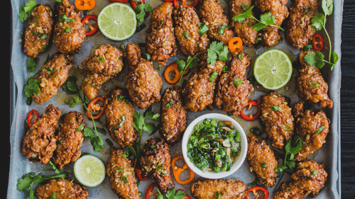 image of a chicken wings tray with lemon wedges and a dip