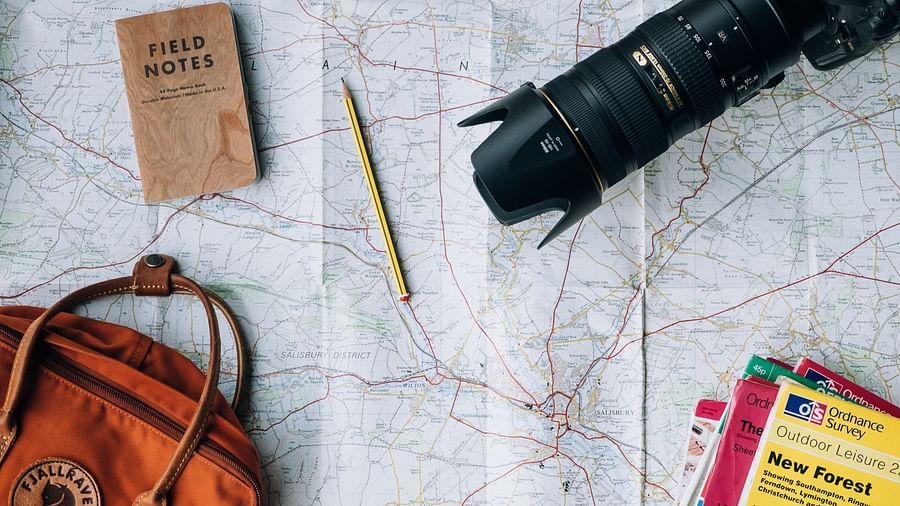 Image of a table with a camera, kanken bag and books on it