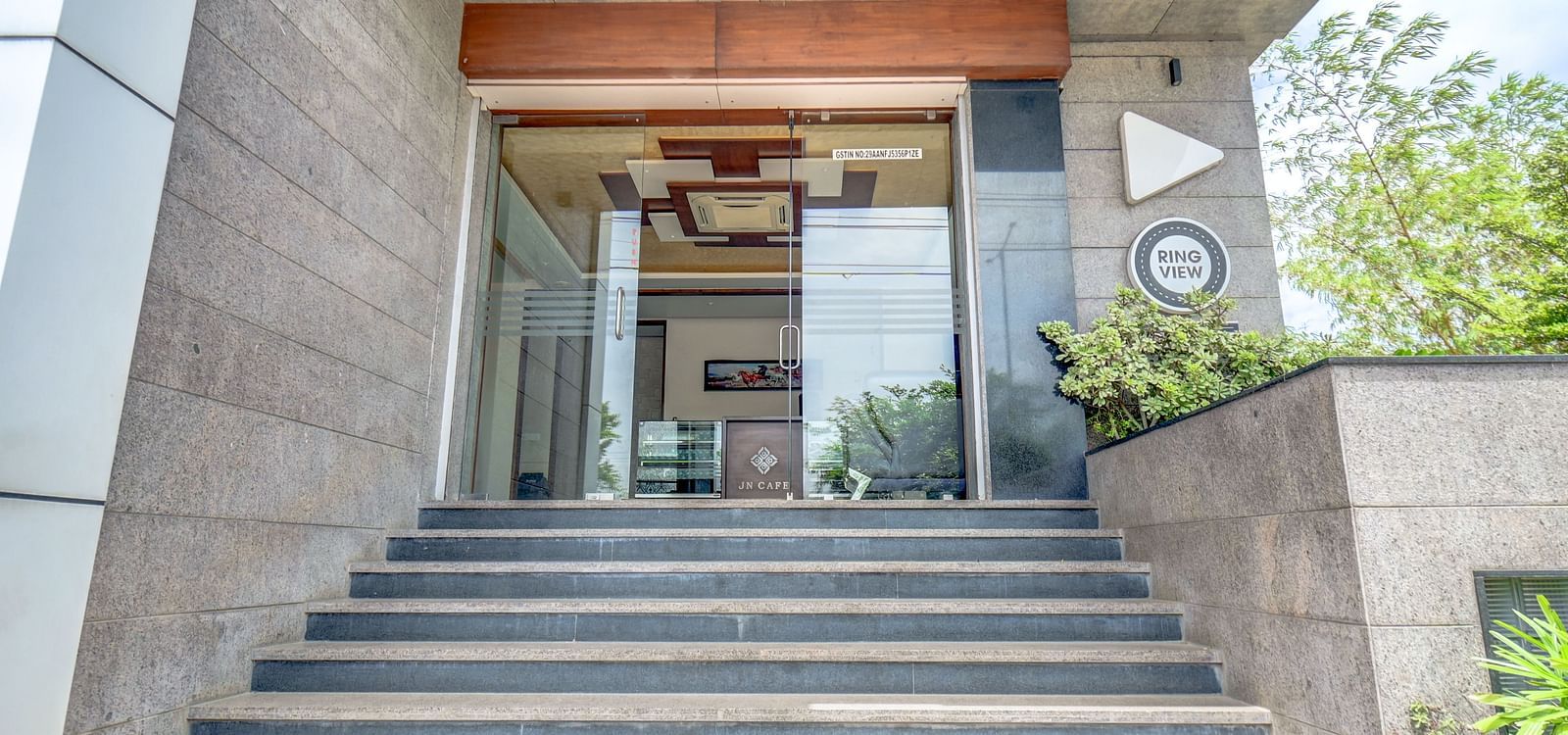 Entrance of Harigovinda's JNStay with stairs leading to the glass door