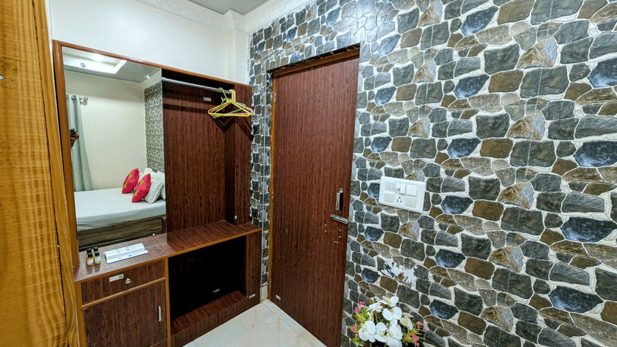 Stylish hotel room entrance with a dressing area and stone accent wall