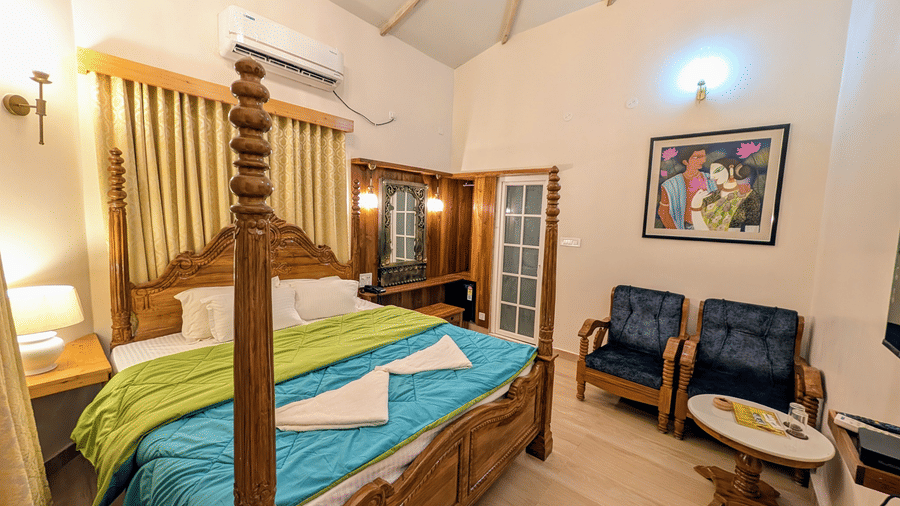 full view  of the pool side cottage featuring a double bed along with cushioned couch in the corner at dip holidays