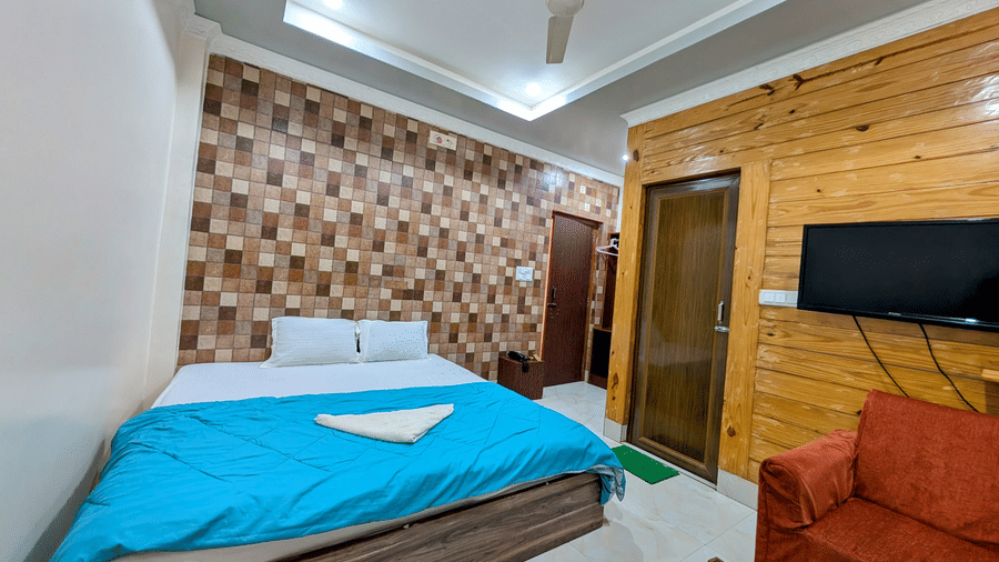 The standard room at dip holidays featuring a double bed with sky blue coloured sheet spread over it.