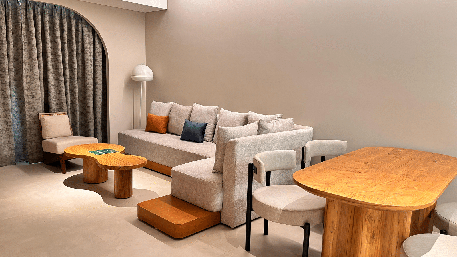 A living area at Swosti Premium Beach Resorts, Puri, with a couch, chairs, and a table.