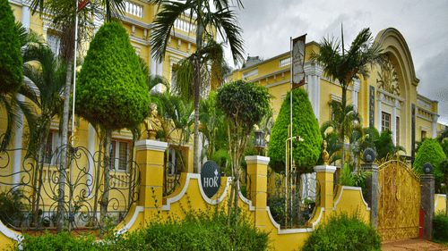 Colourful palace style architecture with lush greenery and palm trees