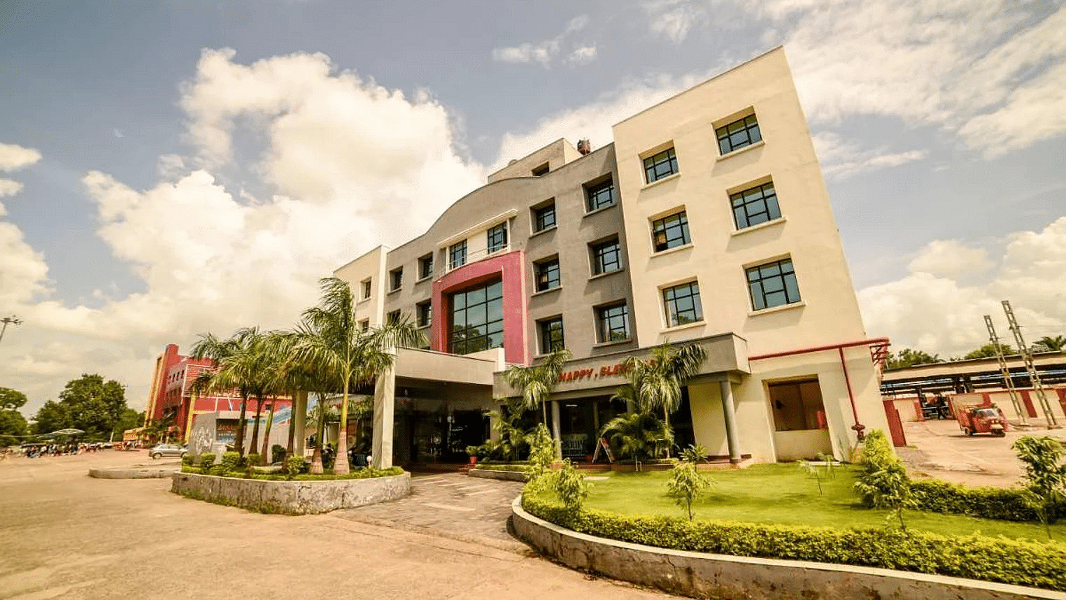 A broader view of the hotel's exterior showcasing its contemporary architecture, vibrant colors, and the landscaped surroundings.