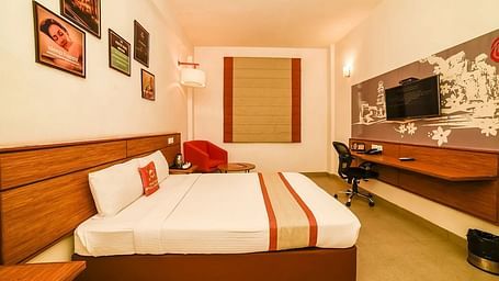 side view image of the queen size bed placed right in front of the wall mounted television - Max Hotel Jabalpur