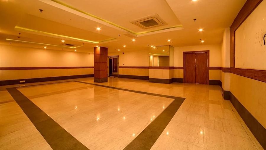 a wide angle shot of our banquet hall with warm lights installed in the false ceiling with central air-conditioning - Max Hotel, Jabalpur