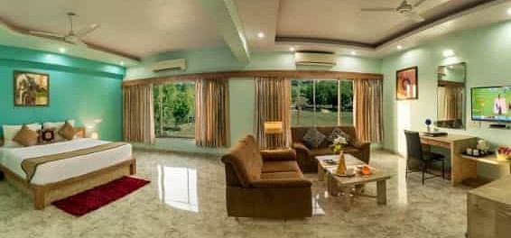 A colourful room offering a double bed, a seating area with sofas, and a television - Lion Lords Inn Rajula