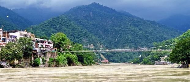 Image of a bridge with lush mountains in the background