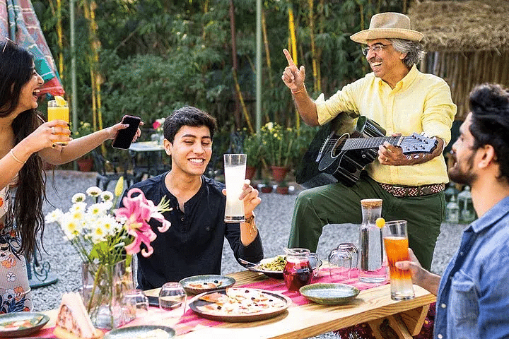 Guests sitting at an outdoor table having food and drinks at Karma Chalets.