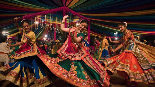 Group of dancers performing energetic Dandiya Garba moves in colourful outfits.