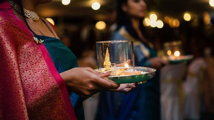 Women draped in Kodava Styled saree holding a plate with things - Aiyanna Lawns, Capitol Village Resort, Madikeri