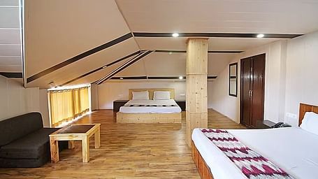 A room at DLS Hotel Devlok, Manali with a double bed and a sofa chair and a coffee table placed in front of it