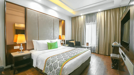 A double bedroom featuring large windows with floor-to-ceiling drapes, a modern workstation, and a wall-integrated television - Flute Boutique By Hotel 91, Jaipur