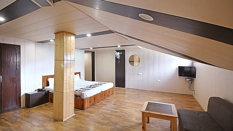 A room at DLS Hotel Devlok, Manali with a sloping roof line and a double bed