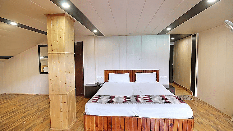 A room at DLS Hotel Devlok, Manali with a double bed and a beam right beside it